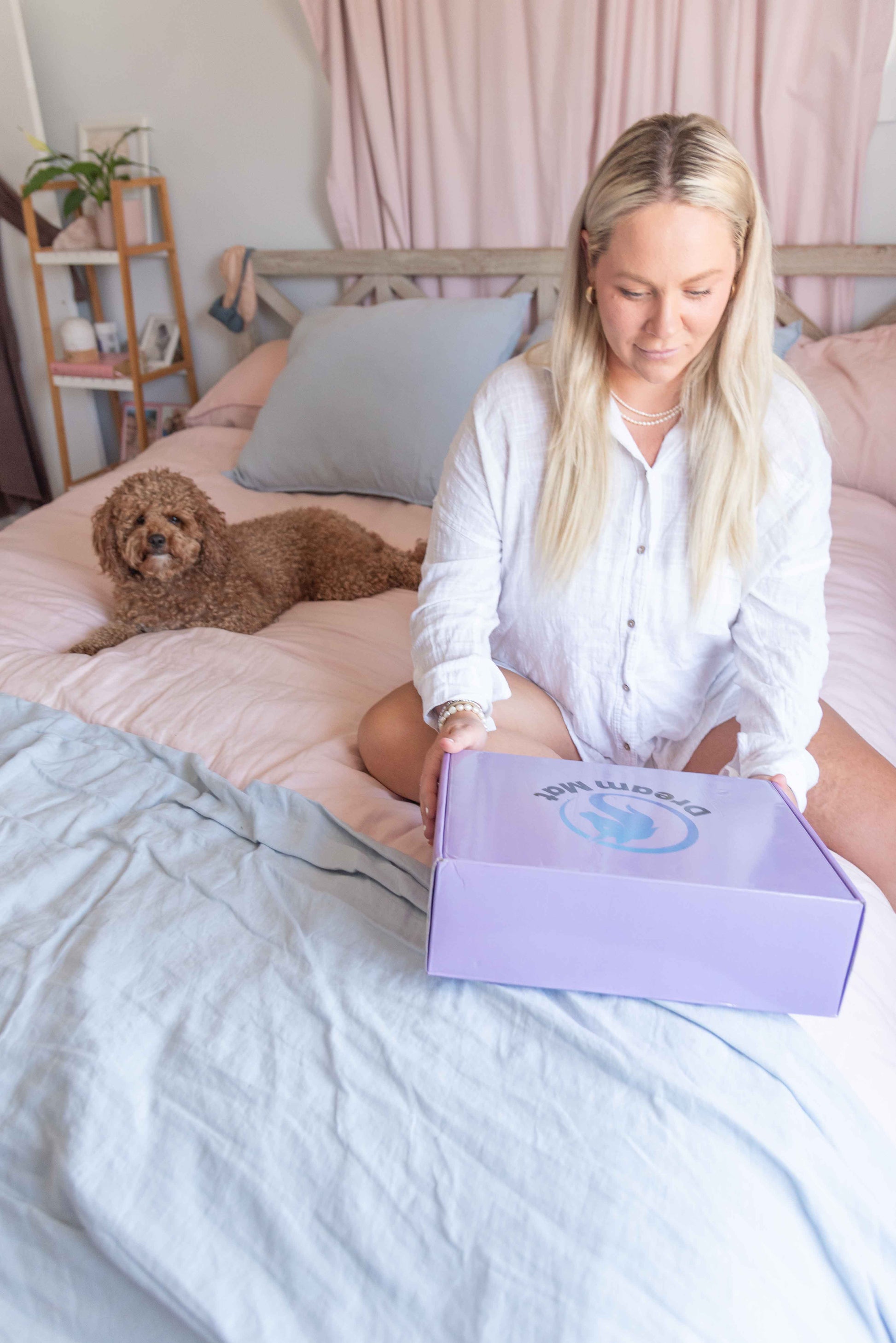 Woman sitting on a bed with a dog,